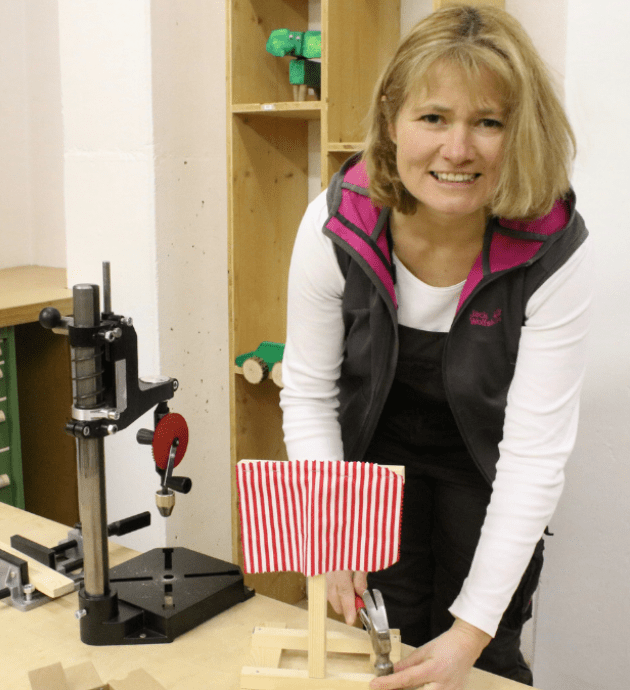 Annemarie Dettendorfer bastelt mit Kindern an einem Holzsegelboot