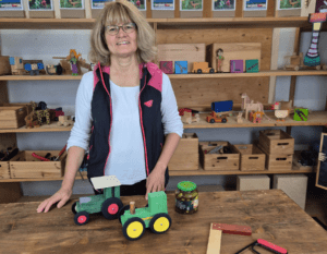 Annemarie mit Holzfahrzeugen
