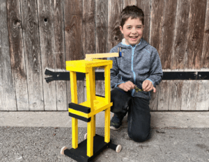 Junge mit gelbschwarzen Holzkran