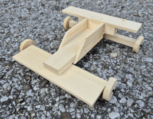 Rennauto aus Holz auf Kieselsteinen